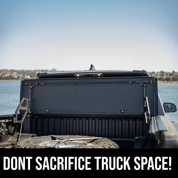 Rear view of a Toyota Tacoma with the TruxArmor QuadAxis Pro quad-fold tonneau cover flipped upright, providing full access to the truck bed.
