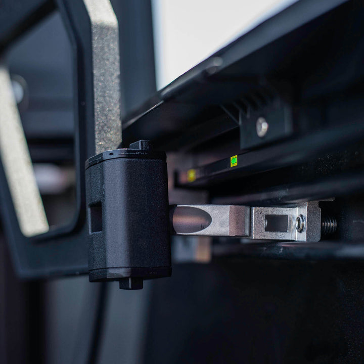 Close-up of the TruxArmor QuadAxis Pro tonneau cover support handle and hinge mechanism mounted to the Toyota Tacoma bed rail.